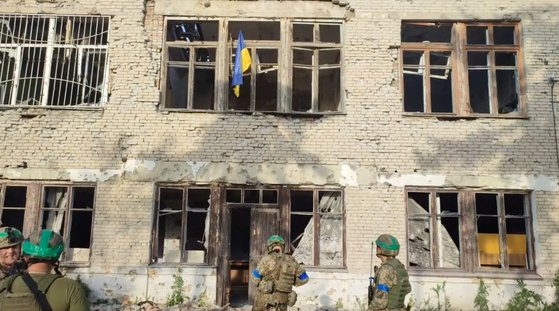 우크라이나 병사들이 11일(현지시간) 러시아 점령지였던 동남부 도네츠크주의 블라호다트네 마을에서 한 건물에 자국 국기를 게양했다. 우크라이나 군 당국은 이날 이 마을을 "해방시켰다"고 발표했다. 로이터=연합뉴스