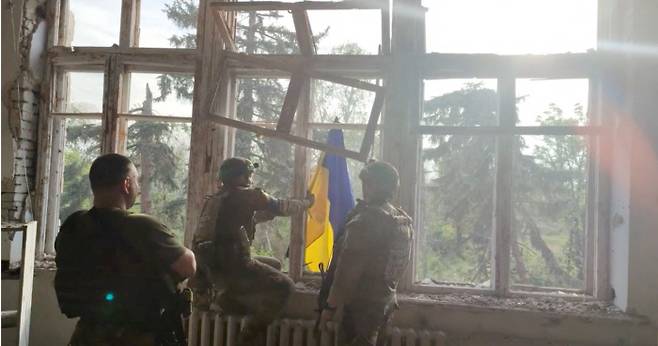 우크라이나 군인들이 11일(현지시간) 대반격으로 처음으로 탈환했다고 주장하는 동부 도네츠크주 블라호다트네 마을의 한 건물에서 국기를 달고 있다. 로이터연합뉴스