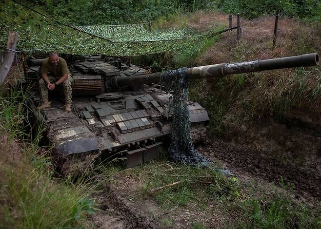 우크라이나 병사가 12일(현지시각) 우크라이나 도네츠크 지역 전선에서 탱크 위에 앉아 있다. 로이터 연합뉴스