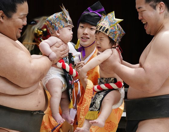 지난 4월 29일 일본 도쿄에서 열린 '아기 울음 스모' 대회에서 스모 선수들이 참가 아기들을 들어올리고 있다. 이 대회는 아기 울음이 악을 물리치는 힘이 있다는 일본 전통 사상에 따라 스모 선수들이 아기들을 들어올렸을 때 누가 더 크게 우는지를 겨루는 경기다. EPA=연합뉴스