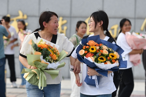 중국 지린성에서 지난 8일 대학 입학시험인 가오카오를 치르고 나온 수험생이 꽃다발을 품에 안고 있다. AFP연합뉴스