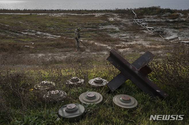 [헤르손=AP/뉴시스]2022년 11월16일(현지시간) 우크라이나 남부 헤르손 외곽 들판에서 우크라이나 군인이 지뢰를 탐지하고 있는 모습. 2023.06.13.
