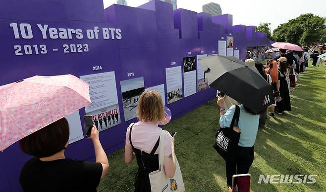 [서울=뉴시스] 조성우 기자 = 그룹 방탄소년단(BTS) 데뷔 10주년 기념 '2023 BTS 페스타'가 열린 17일 오후 서울 영등포구 여의도 한강공원에서 팬들이 BTS 10주년 기념 전시를 관람하고 있다. 2023.06.17. xconfind@newsis.com