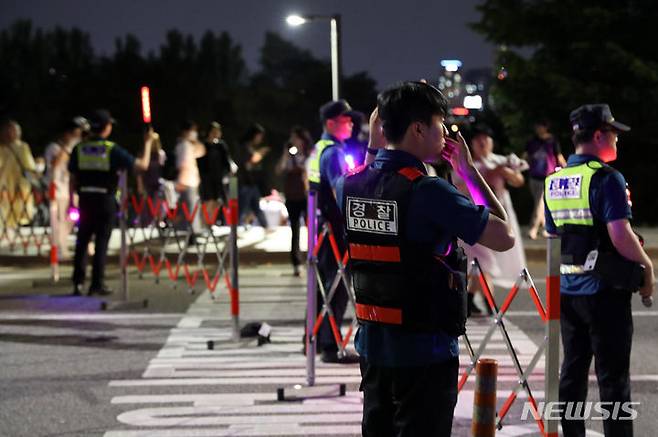 [서울=뉴시스] 조성우 기자 = 17일 오후 서울 영등포구 여의도 한강공원에서 열린 그룹 방탄소년단(BTS) 데뷔 10주년 기념 '2023 BTS 페스타' 불꽃쇼가 끝난 뒤 경찰이 귀가하는 시민들을 안내하고 있다. 2023.06.17. xconfind@newsis.com