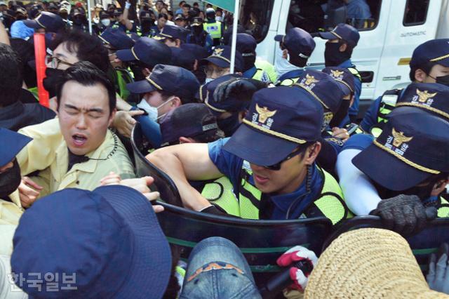 대구시청 소속 공무원이 17일 대구 중구 중앙로대중교통전용지구에서 열리는 제15회 대구퀴어문화축제의 차량 진입을 막던 중 경찰과 몸싸움을 벌이며 찡그린 표정을 짓고 있다. 류수현 기자