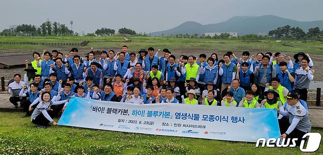 인하대학교와 타 기관 관계자들이 23일 인천 영종도 씨사이드파크 일원에서 염생식물 모종이식 행사를 진행한 후 기념사진을 촬영하고 있다. (인하대 제공) / 뉴스1