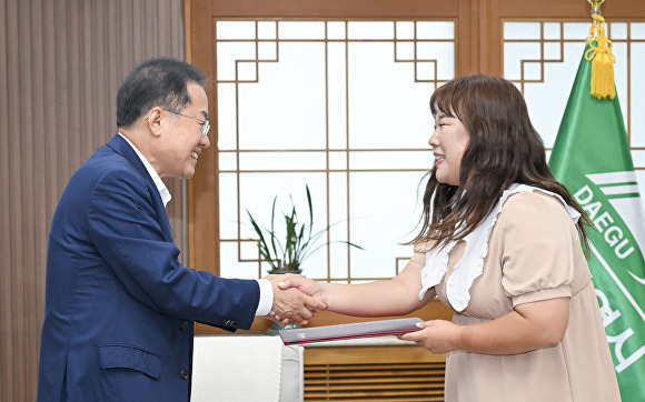 22일 김민경씨(오른쪽)가 홍준표 시장으로부터 고향사랑 기부금 증서를 전달받고 있다. [사진=대구시]