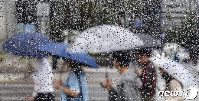 절기상 하지(夏至)인 21일 오전 서울 시내 한 거리에서 우산을 쓴 시민들이 발걸음을 옮기고 있다. 2023.6.21/뉴스1 ⓒ News1 김도우 기자