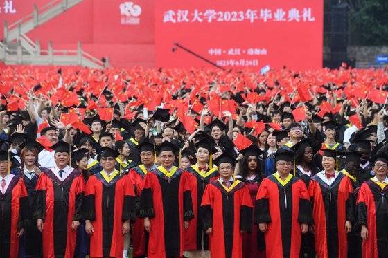 지난 20일 중국 우한대학 졸업식장에서 졸업생과 교수들이 기념 사진을 촬영하고 있다. 중국의 치열한 입시 경쟁이 지난 2년간 야심차게 추진해 온 사교육과의 전쟁을 무력화시켰다고 영국 파이낸셜타임스가 보도했다. AFP=연합뉴스