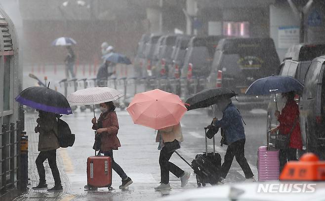 [제주=뉴시스] 우장호 기자 = 제주국제공항 1층 도착장에 우산을 쓴 관광객들이 발걸음을 재촉하고 있다. 뉴시스DB. woo1223@newsis.com