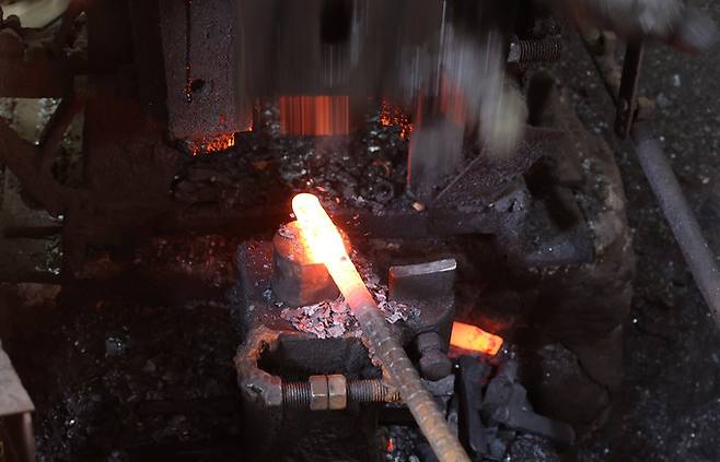 50년 세월을 함께한 단조기가 무른 쇠에 강한 쇠를 붙이는 이중 복합강 작업을 하고 있다.