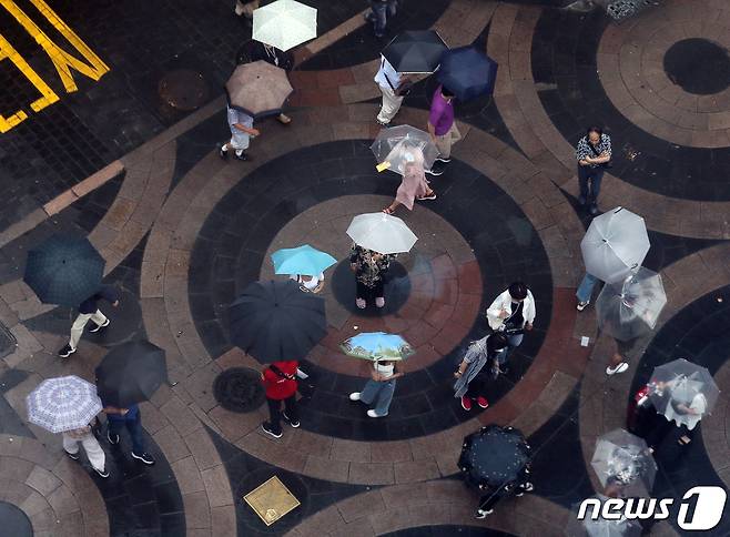 본격적인 장마가 시작된 26일 서울 중구 명동에서 우산 쓴 시민들과 외국인 관광객들이 발걸음을 재촉하고 있다. 2023.6.26/뉴스1 ⓒ News1 김진환 기자