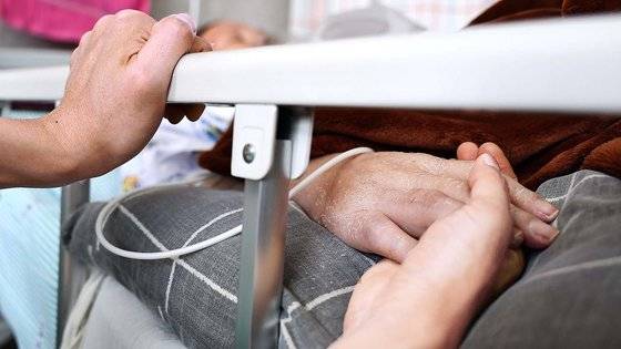 지난 4월 서울적십자병원 호스피스 병동에서 환자 가족이 환자의 손을 잡고 있다. 김종호 기자