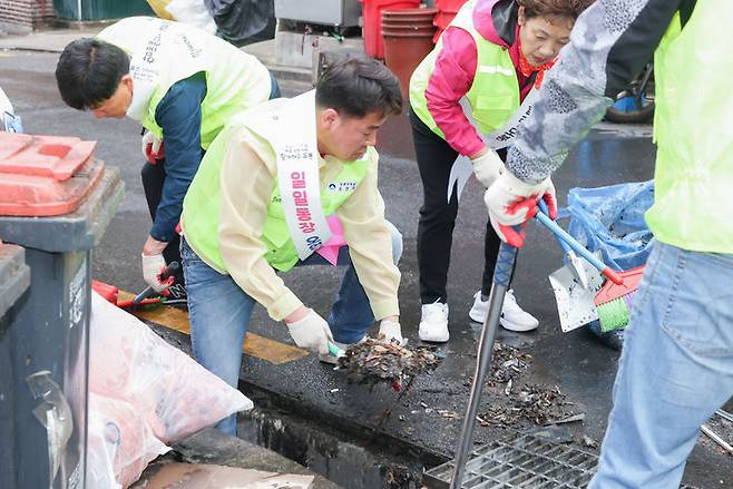 [서울=뉴시스]빗물받이 청소 중인 오언석(왼쪽 두번째) 도봉구청장.(사진=도봉구 제공) *재판매 및 DB 금지