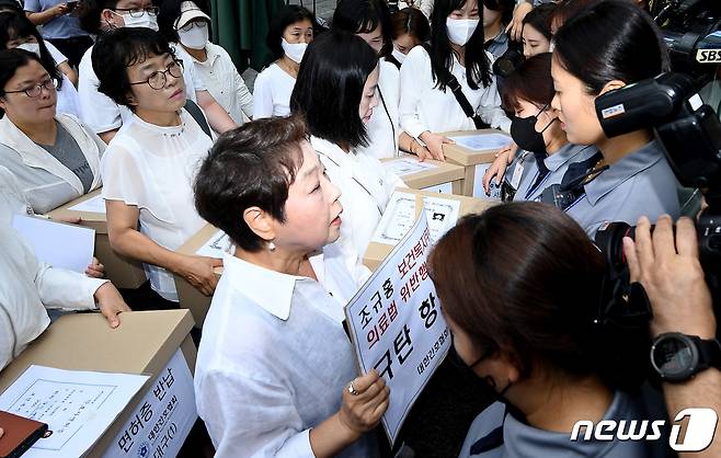 대한간호협회 소속 간호사들이 26일 오전 세종시 정부세종청사 보건복지부앞에서 '간호법 허위사실 유포·불법진료 묵인 보건복지부 규탄' 기자회견을 마친 뒤 간호사 면허증 반납을 위해 청사 앞에서 대치하고 있다.2023.6.26/뉴스1 ⓒ News1 김기남 기자