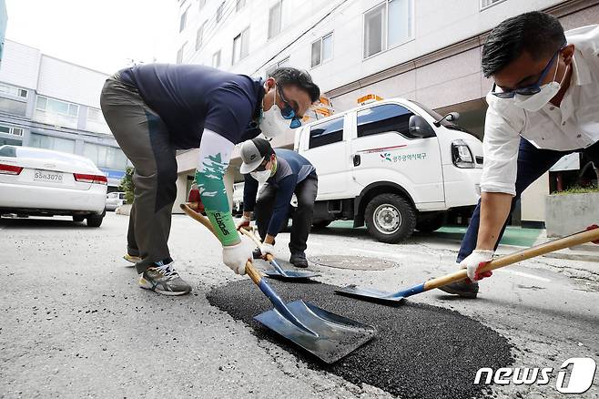 광주 북구 주택가 이면도로에서 북구 건설과 도로관리팀 직원들이 집중호우로 생긴 포트홀 복구 작업을 하고 있다./뉴스1