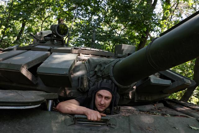 우크라이나 병사가 19일(현지 시간) 도네츠크주 바흐무트의 전선 인근에서 러시아군으로부터 탈취한 탱크에 들어가고 있다. 바흐무트=로이터 연합뉴스