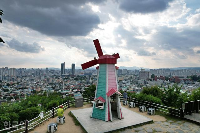 대동하늘공원에서는 풍차 뒤편으로 대전역 부근 도심 풍광이 시원하게 펼쳐진다.