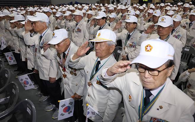 지난 25일 오전 서울 중구 장충체육관에서 열린 6.25 73주년 행사에서 영웅의 제복 입은 6.25 참전용사들이 국기에 경례하고 있다. 연합뉴스