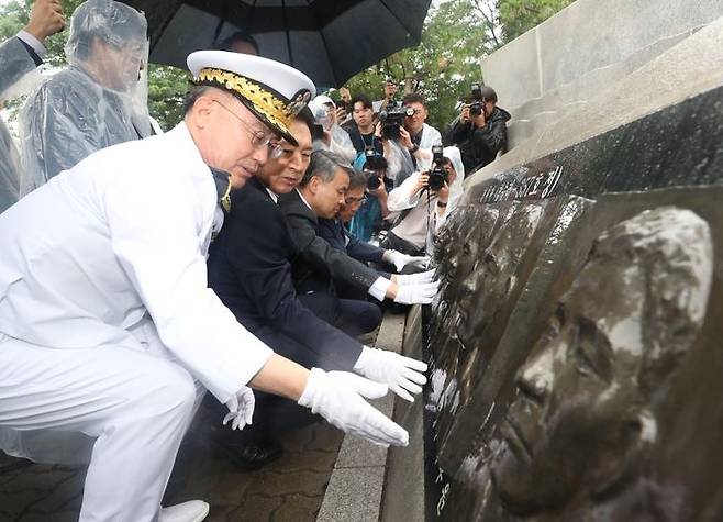 김기현 국민의힘 대표가 29일 오전 경기 평택시 해군 제2함대사령부에서 열린 '제2연평해전 승전 21주년 기념식'에서 유가족이 해전 영웅들의 얼굴 부조상을 어루만지고 있다. (공동취재사진) ⓒ뉴시스