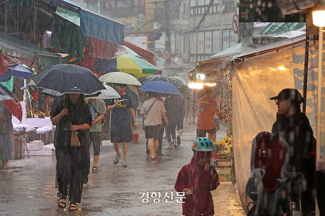 수도권 대부분 지역에 호우주의보가 발령된 29일 지난해 폭우로 침수 피해가 발생한 서울 동작구 남성사계시장에서 시민들이 우산을 쓴 채 걷고 있다.