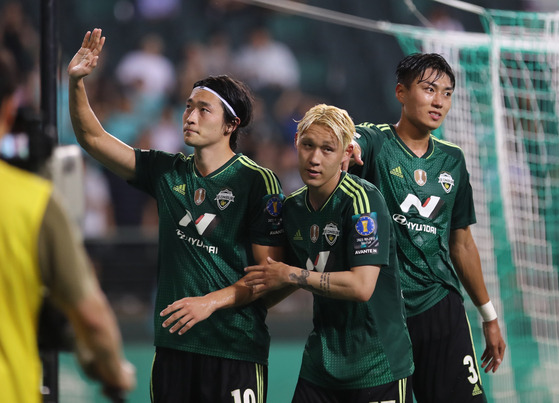 Jeonbuk Hyundai Motors' Cho Gue-sung, left, waves to fans after scoring a goal against Gwangju FC during an FA Cup match at Jeonju World Cup Stadium in Jeonju, North Jeolla, on Wednesday. [YONHAP]