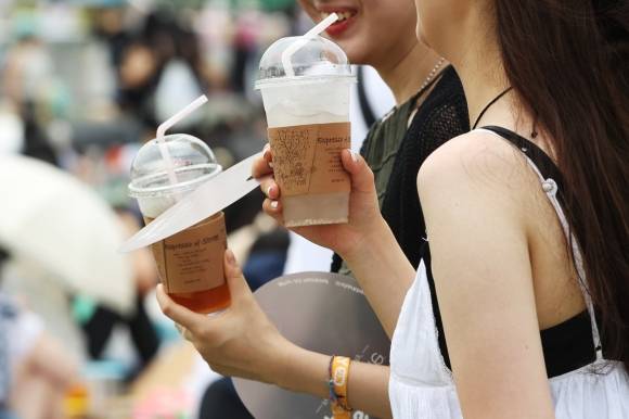 25일 오후 송파구 올림픽공원에서 열린 ‘2023년 서울 파크 뮤직 페스티벌’에서 관람객들이 음료를 마시고 있다.  연합뉴스