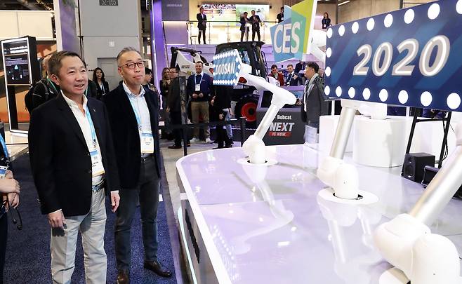 국제가전전시회 'CES 2020'(Consumer Electronics Show) 이틀째인 2020년 1월 8일(현지시각) 미국 네바다주 라스베이거스 컨벤션센터 두산 전시장에서 박정원 두산그룹 회장(왼쪽)과 박지원 두산중공업 회장이 두산로보틱스 협동로봇의 사인 스피닝(Sign Spinning) 퍼포먼스를 지켜보고 있다. / 뉴스1