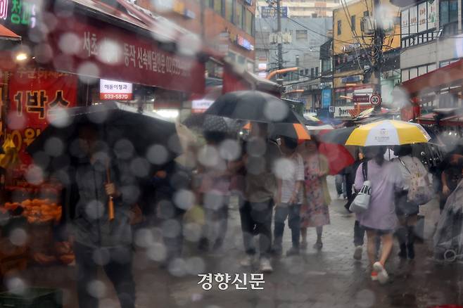 수도권 대부분 지역에 호우주의보가 발령된 지난 29일 지난해 폭우로 침수 피해가 발생한 서울 동작구 남성사계시장에서 시민들이 우산을 쓴 채 걷고 있다. 조태형 기자