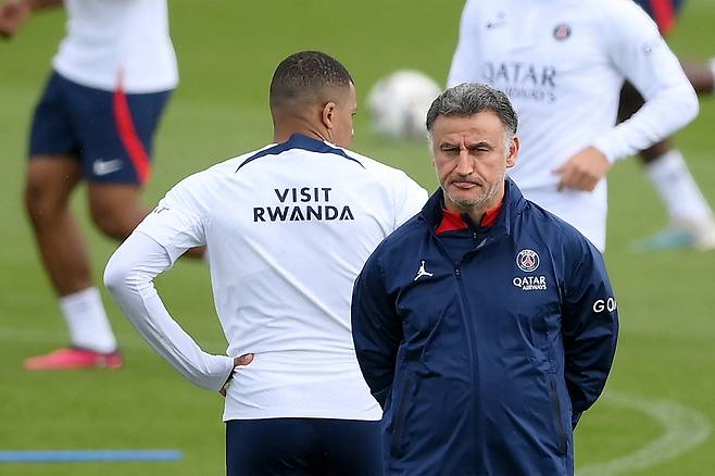 (FILES) Paris Saint-Germain's French forward Kylian Mbappe (L) and Paris Saint-Germain's French head coach Christophe Galtier attend a training session in Saint-Germain-en-Laye, on the outskirts of Paris, on May 5, 2023, on the eve of the French L1 football match against Troyes. PSG head coach Christophe Galtier, who is preparing to leave the club and his son have been "in police custody at the Nice judicial police since 8.45am on Friday" Nice public prosecutor Xavier Bonhomme told AFP on June 30, 2023. (Photo by FRANCK FIFE / AFP)