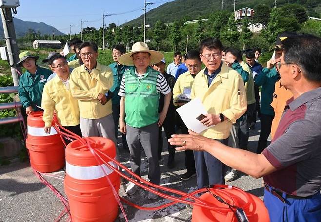 이철우 경북지사(사진 중앙)가 집중호우 피해지역인 영주시 봉현면 하촌리 교량유실 현장을 찾아 피해현황을 설명듣고 있다.