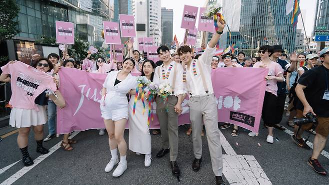 국제앰네스티 한국지부 관계자인 킴·백팩 커플(앞줄 오른쪽)과 임신 8개월차 김규진·김세연씨 커플(왼쪽)이 1일 열린 제24회 서울퀴어문화축제에 참가해 서울 을지로 일대에서 청계천 삼일교까지 행진하며 혼인 평등 촉구를 위한 ‘그냥 결혼이야 JUST MARRIAGE’ 캠페인을 펼치고 있다. 국제앰네스티 한국지부 제공