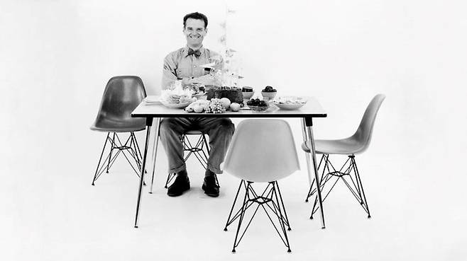 프랑스 파리 에펠탑을 닮은 다리 구조로 '에펠 의자'라는 별명을 얻은 DSW(Dining height, Side chair, on Wood base)에 앉아있는 찰스 임스. DSW는 앞서 출시한 임스 DAR 팔걸이 의자를 좁게 개조한 디자인이다. [ⓒEams Office]