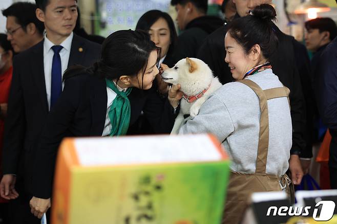 김건희 여사가 지난 4월14일 대전 중구 태평전통시장을 방문해 한 상인이 키우는 유기견 로또와 인사하며 뽀뽀하고 있다. (대통령실 제공) 2023.4.14/뉴스1 ⓒ News1 안은나 기자