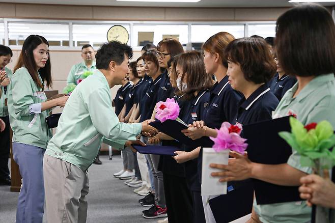 김종부 엔유씨전자 회장(왼쪽)이 장기근속자 직원들에게 표창장을 수여하고 있다.