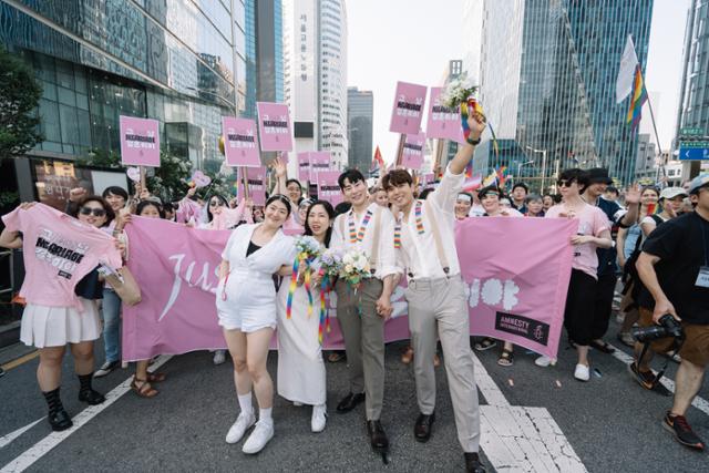 1일 서울 을지로 일대에서 열린 24회 서울퀴어퍼레이드에 참여한 김규진·김세연씨와 킴·백팩씨 동성커플이 결혼식 퍼포먼스를 벌이고 있다. 국제앰네스티 한국지부 제공