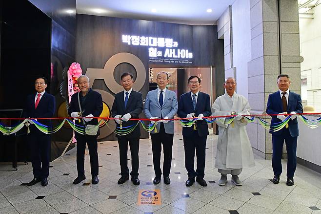 백승주 전쟁기념사업회장(오른쪽에서 세번째), 이제철 풍산화동양행 사장, 이흥우 박정희대통령 기념관 전시실장 등이 '박정희 대통령과 철의 사나이들' 특별기획전 개막식에서 리본을 자르고 있다.(전쟁기념사업회 제공)