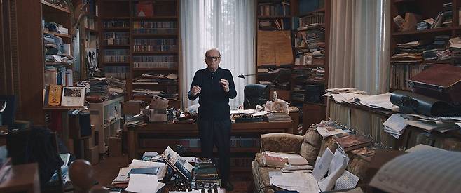다큐멘터리 영화 ‘엔니오: 더 마에스트로’에서 엔니오 모리코네가 집에서 작곡한 음악에 맞춰 지휘를 해보고 있다. ㈜씨네필운 제공