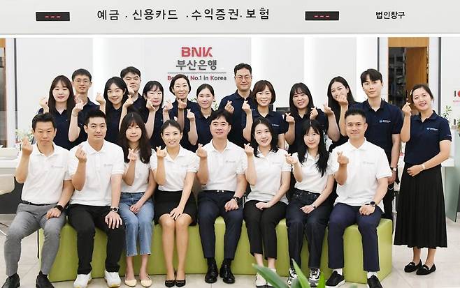 BNK금융그룹 임직원들이 ‘2030부산세계박람회’ 유치 응원 티셔츠를 입고 기념사진을 촬영하고 있다./제공=BNK금융