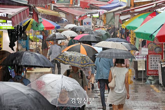 수도권 대부분 지역에 호우주의보가 발령된 지난달 29일 지난해 폭우로 침수 피해가 발생한 서울 동작구 남성사계시장에서 시민들이 우산을 쓴 채 걷고 있다. 조태형 기자