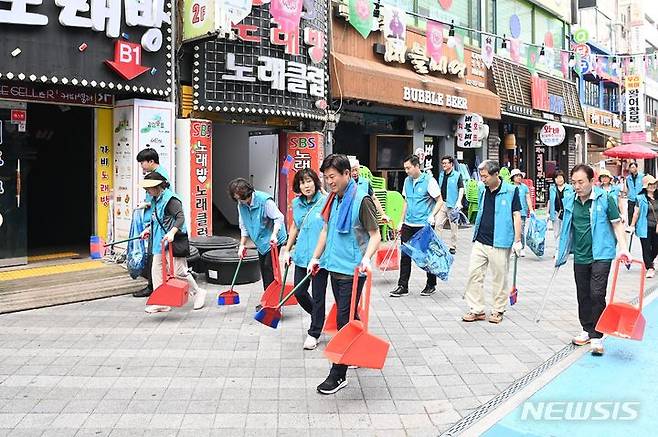 [부천=뉴시스] 정일형 기자 = 조용익 부천시장이 취임 1주년을 맞은 지난 3일 신중동 먹자거리에서 환경정비 활동을 하며, 현장 곳곳을 살펴보고 있다. (사진은 부천시 제공)