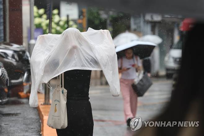 우산이 없어서 (서울=연합뉴스) 신현우 기자 = 전국 곳곳 장맛비가 내린 4일 오후 서울 명동에서 한 시민이 옷으로 비를 막으며 이동하고 있다. 2023.7.4 nowwego@yna.co.kr