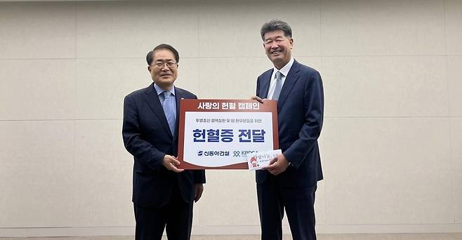 진현기 신동아건설 대표(오른쪽)가 한국혈액암협회 장태평 한국혈액암협회장에게 헌혈증을 전달한 후 기념촬영을 하고 있다. /신동아건설 제공