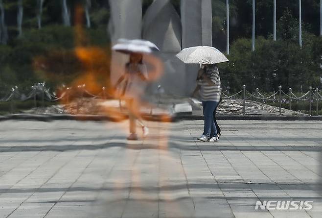 [서울=뉴시스] 정병혁 기자 = 더운 날씨가 이어진 지난 3일  서울 송파구 올림픽공원 평화의문에 설치된 성화 뒤 도심풍경이 아른거리고 있다. 2023.07.03. jhope@newsis.com