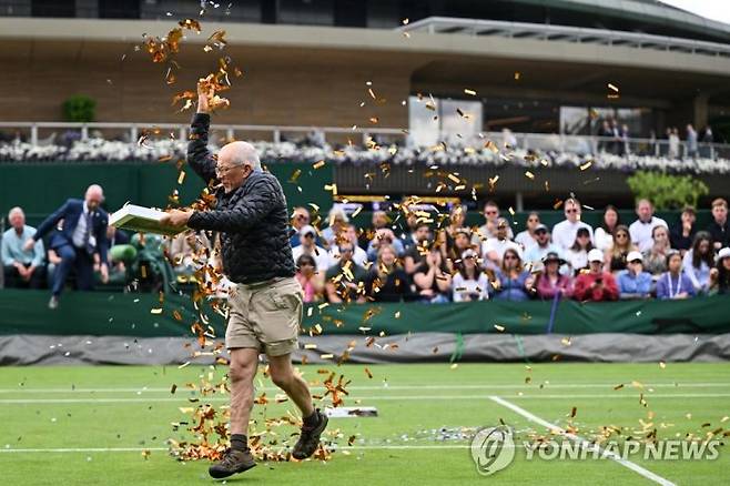 경단체 '저스트 스톱 오일'(Just Stop Oil) 회원이 5일(현지시간) 윔블던 테니스 대회에서 반짝이 테이프 등을 뿌리며 시위하고 있다. [사진출처=AFP·연합뉴스]