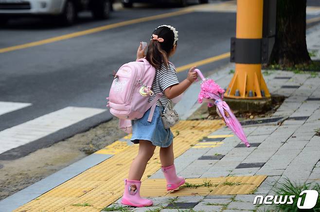 5일 오전 광주 남구의 한 초등학교 앞에서 한 초등학생이 장화와 우산을 신고 등교하고 있다. 2023.7.5/뉴스1 ⓒ News1 이승현 기자