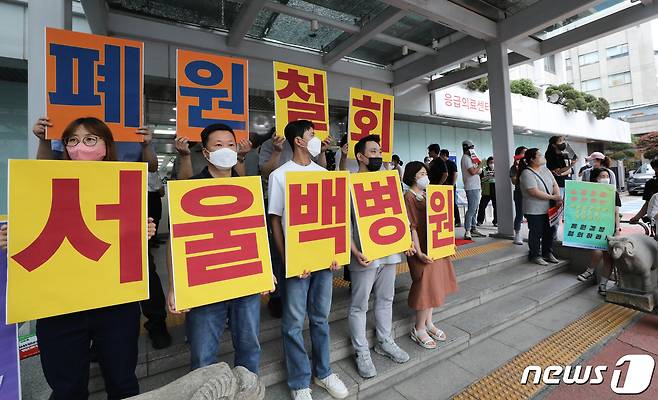 20일 서울 중구 서울백병원에서 열리는 폐원안에 대한 이사회에 항의하는 직원들이 손피켓을 들고 있다. 2023.6.20/뉴스1 ⓒ News1 허경 기자