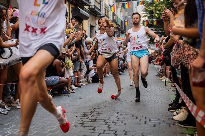 프라이드 주간인 지난 7월 29일(현지시간) 스페인 마드리드에서 열린 연례 하이힐 경주에서 참가자들이 하이힐을 신고 달리고 있다. 참가자들은 굽이 최소 15센티미터 이상인 신발을 신어야 한다./AP 연합뉴스
