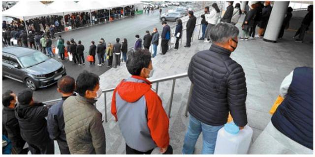 전북 익산시에서 지역민에게 직접 요소수 판매에 나섰던 지난 2021년 11월 9일, 익산 실내체육관 앞에 통을 든 시민들이 길게 줄지어 서 있다. 뉴시스
