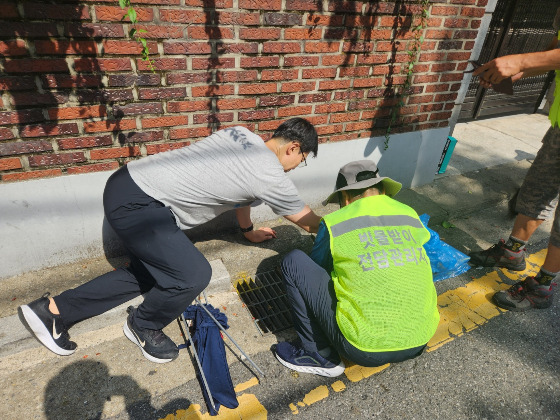 빗물받이 전담관리반 1조 조장 장동석씨(오른쪽)와 기자(왼쪽). 빗물받이 쓰레기를 함께 치우는 중./사진=형광조끼 나도 입고 싶은데, 생각했던 남형도 기자